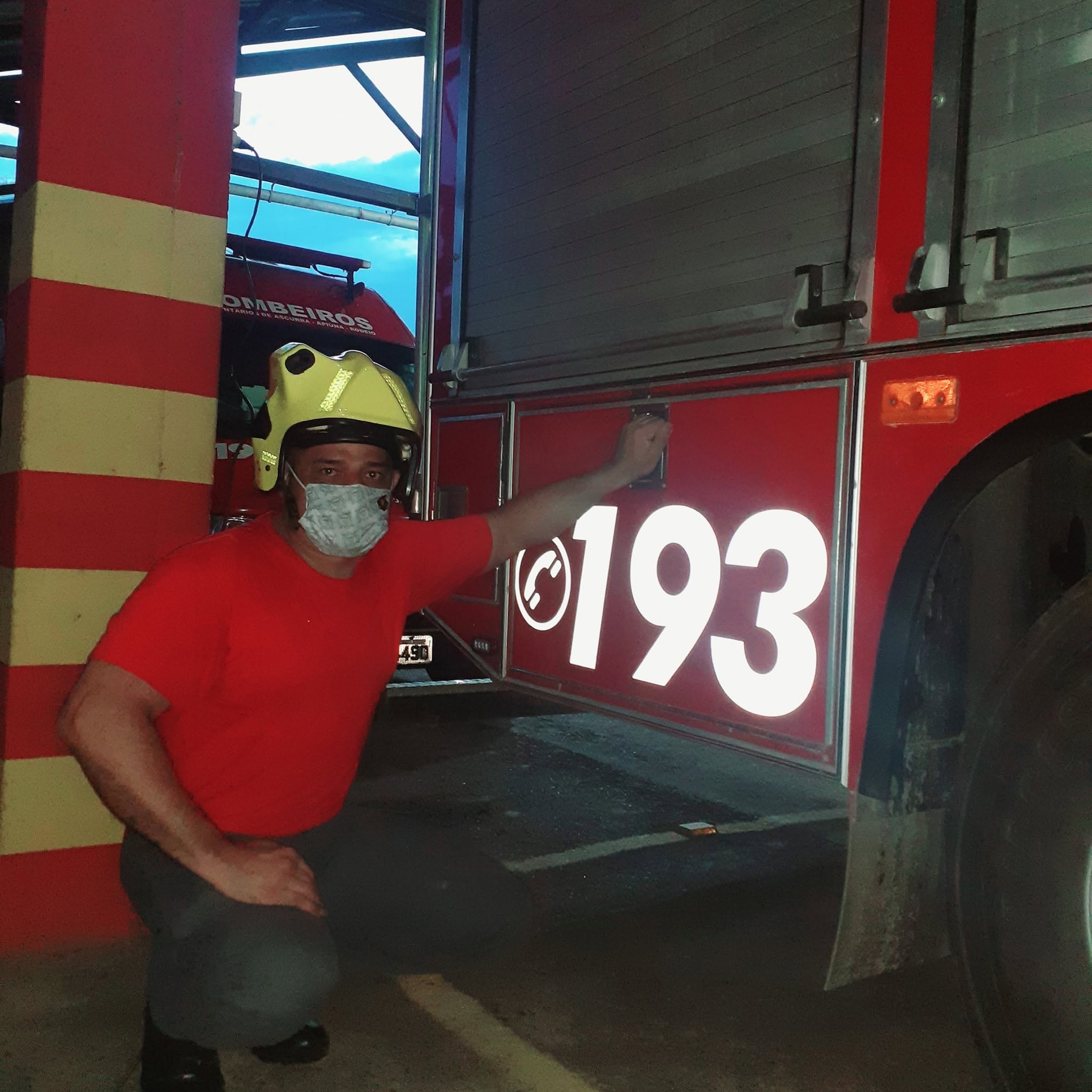 Instrutor de capacete ao lado de caminhão de bombeiros com o número 193