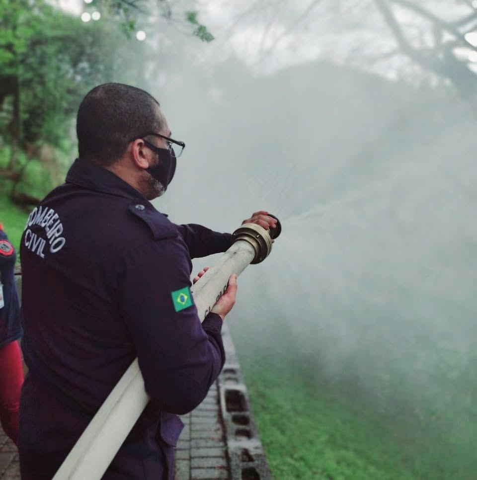 Bombeiro civil operando mangueira em treinamento de combate a incêndio