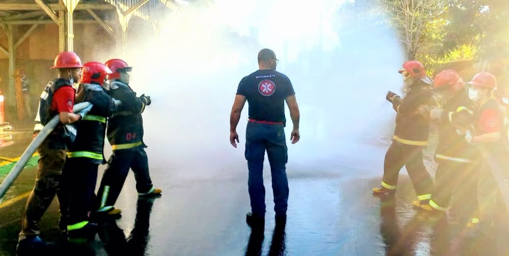 Treinando combate a incêndio com mangueira e fumaça em simulado prático