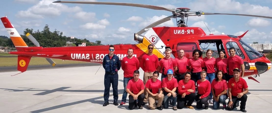 Turma de alunos ao lado do helicóptero Arcanjo do SAMU e Bombeiros