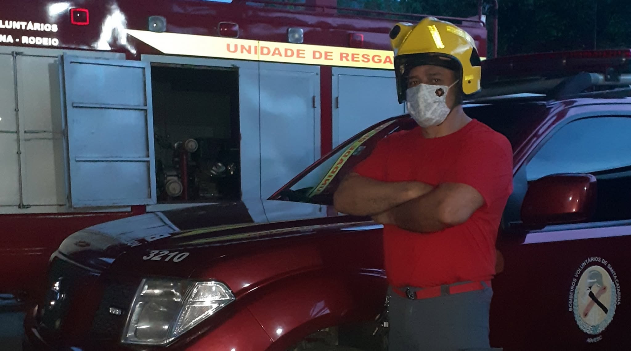 Instrutor com capacete diante de unidade de resgate dos bombeiros